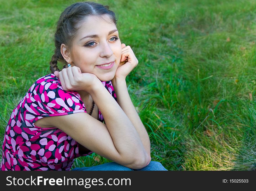 The beautiful girl sitting on a grass. The beautiful girl sitting on a grass