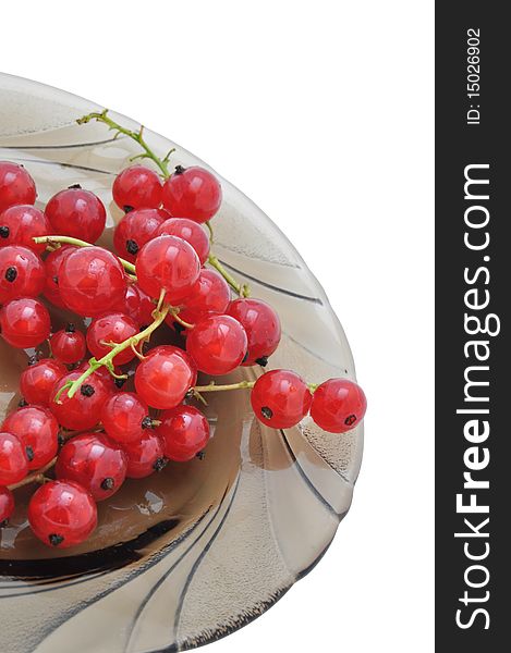 Picture of clusters of red currant on a dish on a white background