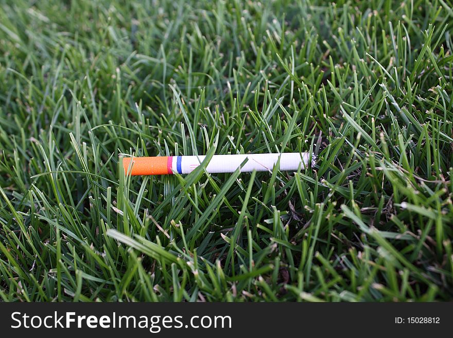 Orange red-white-blue ciggy in Dutch grass. Orange red-white-blue ciggy in Dutch grass