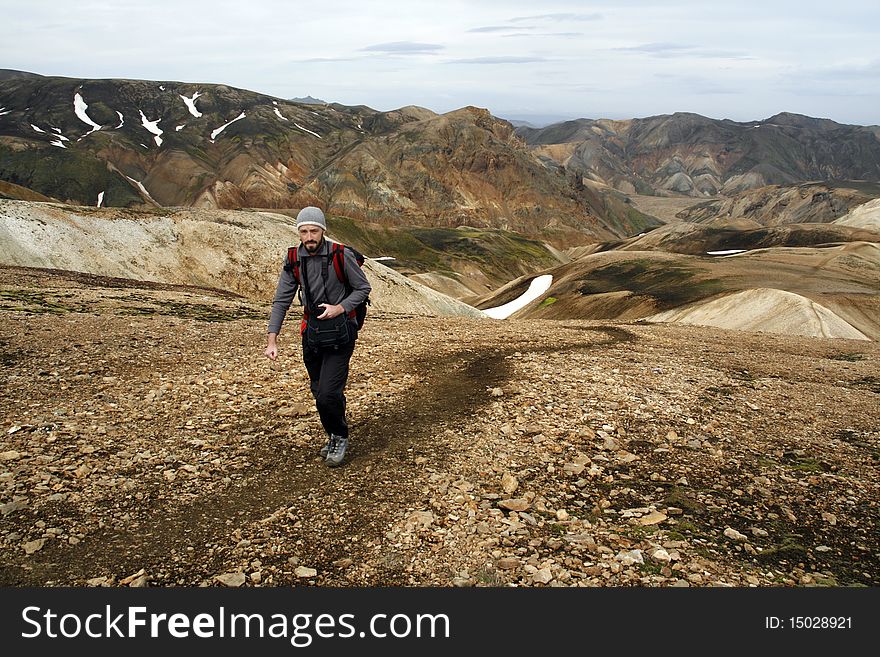 Young male traveller, photographer hiking in Landmannalaugar region of Iceland