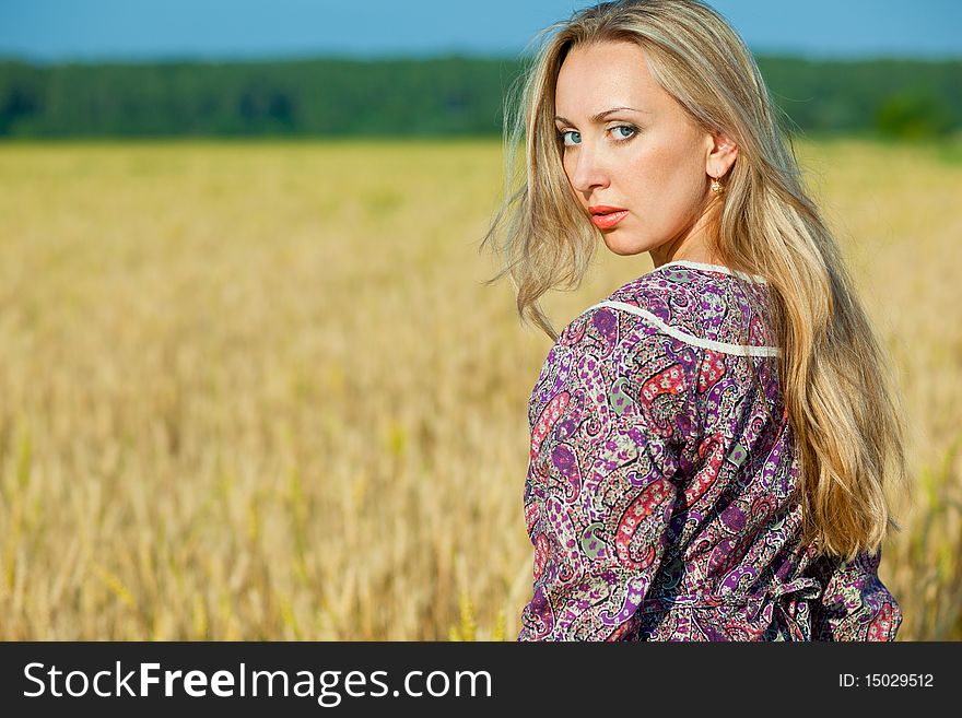 Young beauty girl in the wheat field