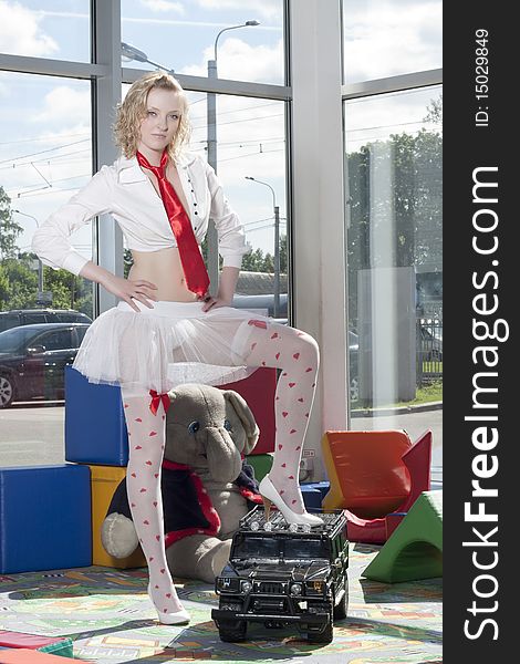 Fashion model stylized as babydoll with toy car at the nursey. Dealer autocentre LAURA in St.-Petersburg