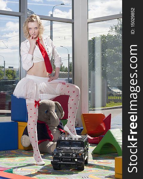 Fashion model stylized as  babydoll with toy car at the nursey. Dealer autocentre LAURA in St.-Petersburg