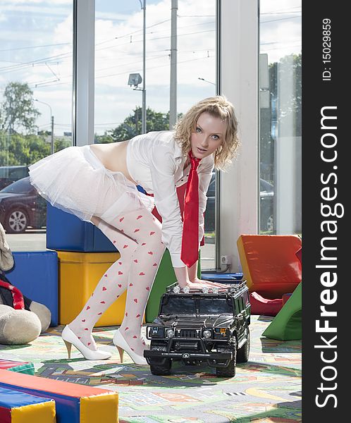 Fashion model stylized as babydoll with toy car at the nursey. Dealer autocentre LAURA in St.-Petersburg