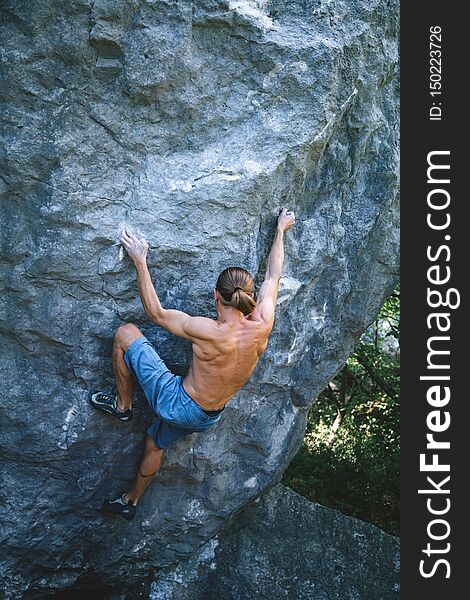 Athletic man climbing hard boulder problem in forest using special crash pads. Sport climbing, bouldering. Outdoor. Athletic man climbing hard boulder problem in forest using special crash pads. Sport climbing, bouldering. Outdoor.
