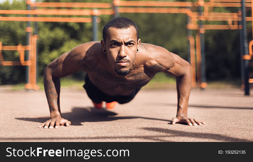 Muscular Man Doing Push Ups On Sports Ground