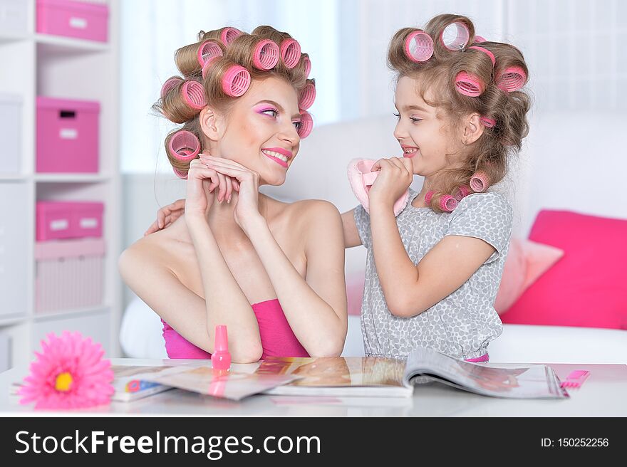 Portrait of happy  Mother and little daughter with hair curlers