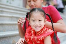 Portrait Of Mother Tying Her Daughter`s Hair. Two Tied Ponytails Hairs. Child Girl Looking At Camera Stock Photo