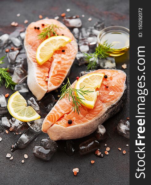 Raw salmon steaks and ingredients on a black slate board