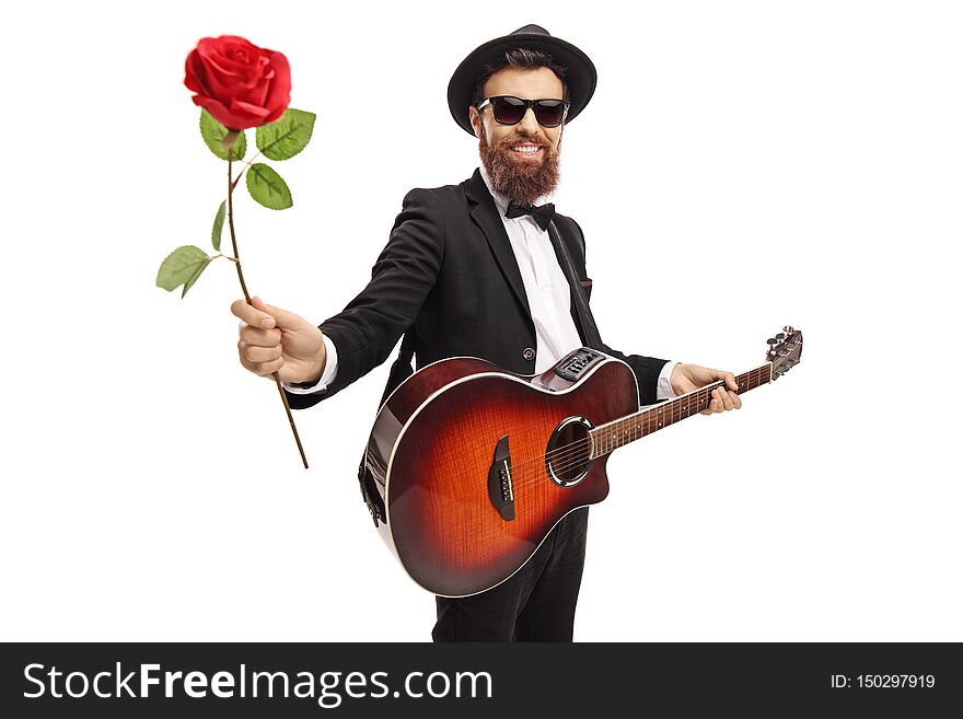 Young bearded man with an acoustic guitar holding a red rose isolated on white background