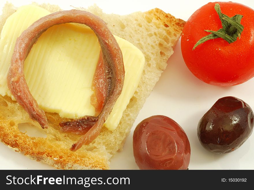 Bread, butter, black olives, anchovies and tomatoes. Bread, butter, black olives, anchovies and tomatoes