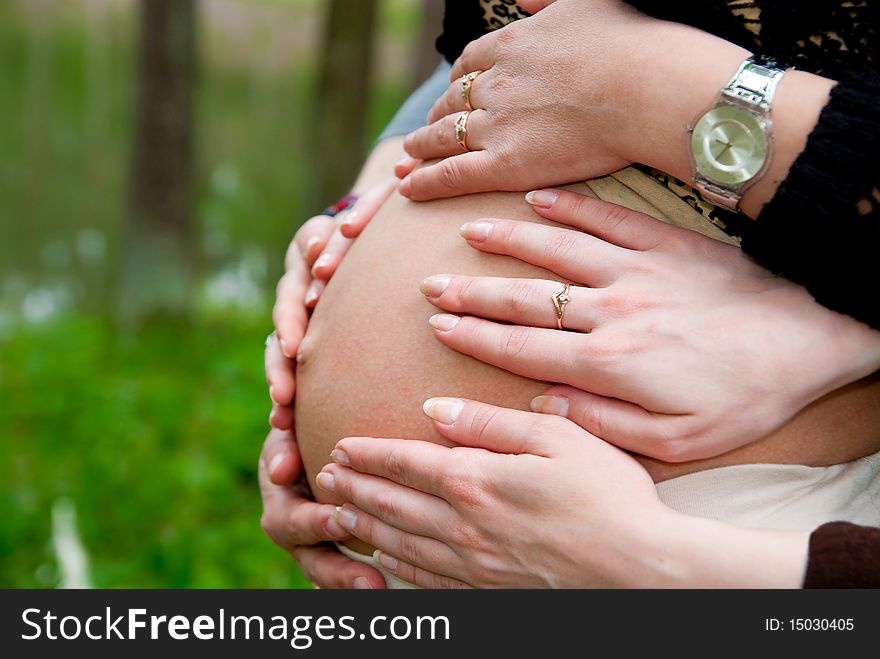 Girls hands on pregnant woman