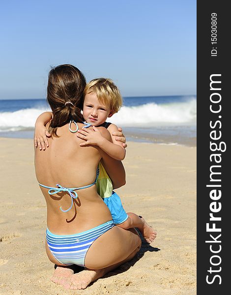 Summer vacation: Happy child hugging her mother on the beach