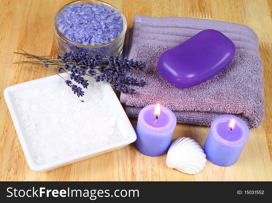 Violet colored spa and wellness accessories with lavender flowers. Burning candles. Violet colored spa and wellness accessories with lavender flowers. Burning candles