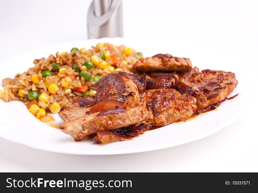 Stifried vegetable rice with soy and spices and fried pork with onions and tomatos. Stifried vegetable rice with soy and spices and fried pork with onions and tomatos