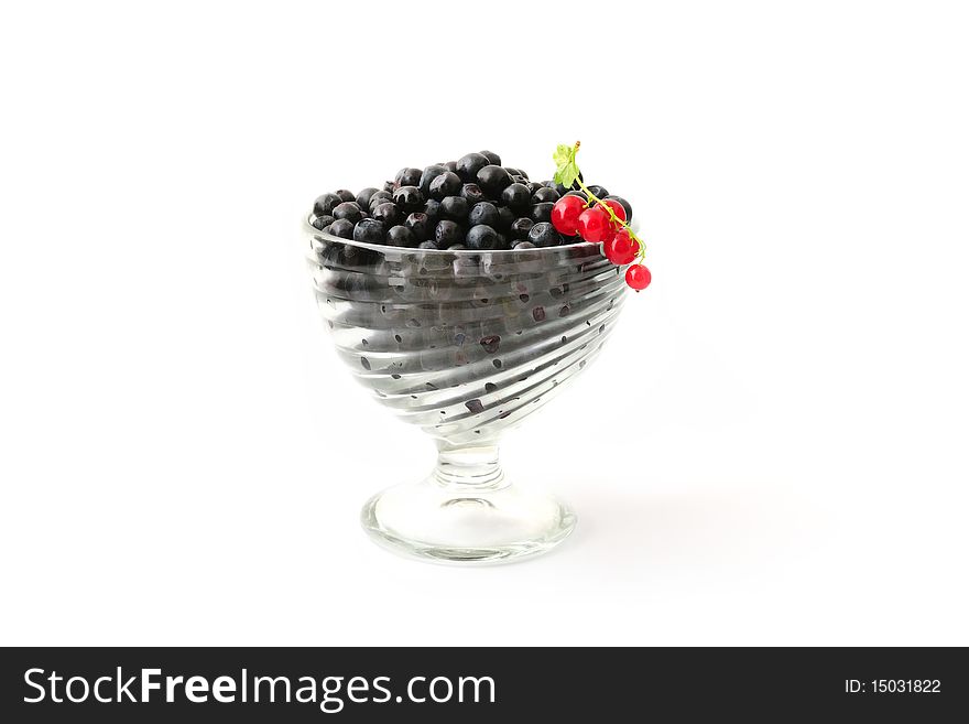 Blueberries and red currant in a glass bowl isolated on white. Blueberries and red currant in a glass bowl isolated on white