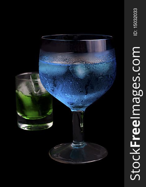 Blue Curacao and absinthe in a  glass on a black background