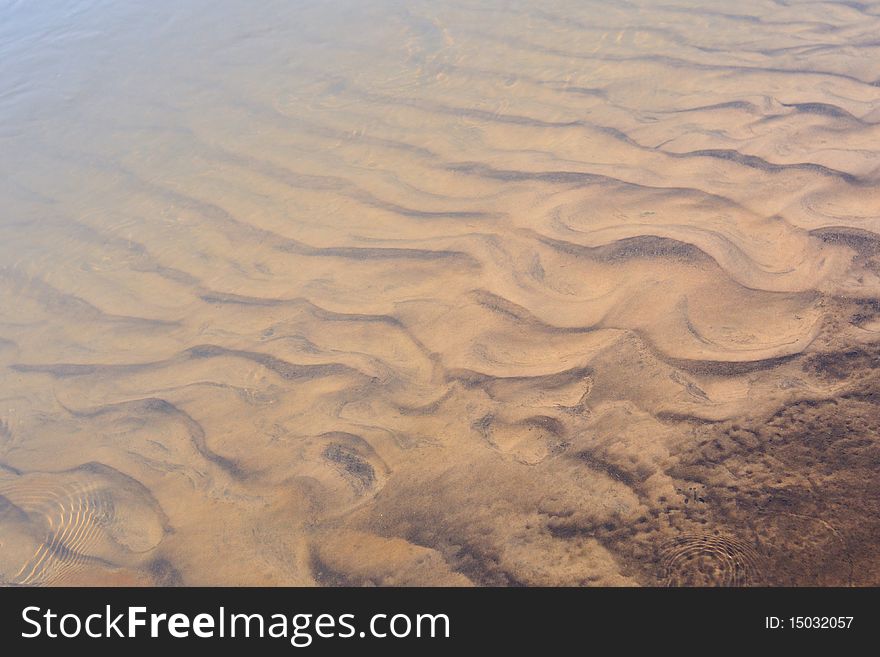 Scenic sand waves on the river bottom under transparent water stream