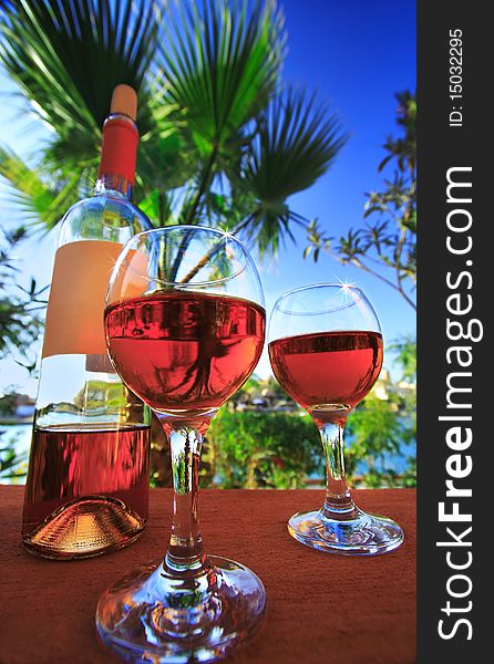 Two wineglasses. Background of the sea and the blue sky