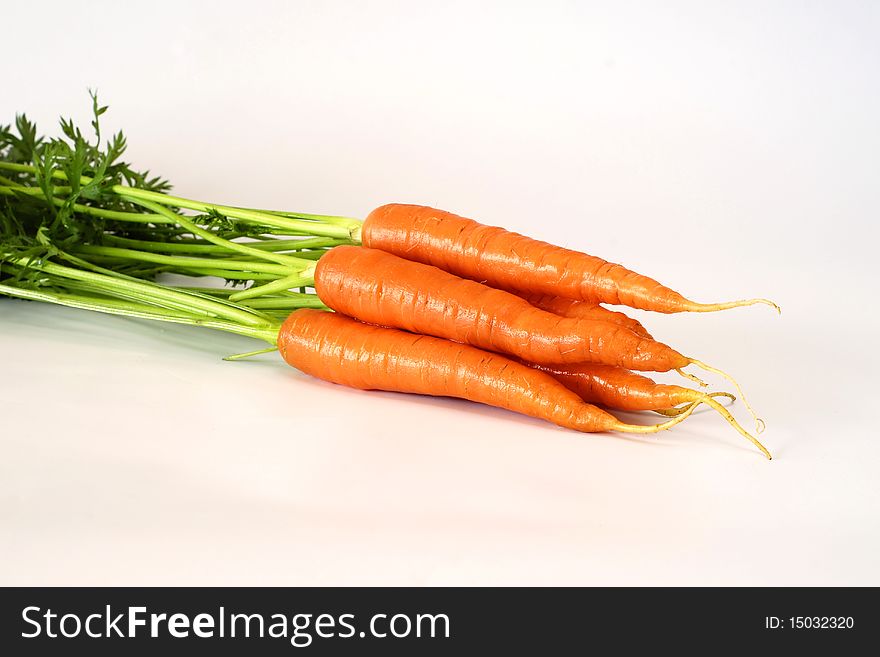 A few carrots with tops on the white background. A few carrots with tops on the white background