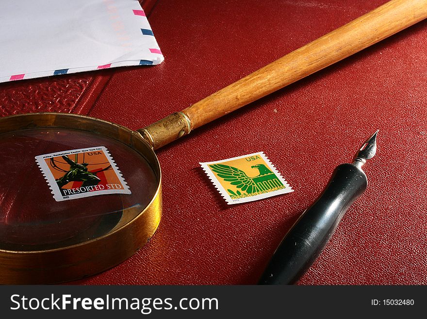 The old ink pen, magnifying glass and post envelope with marks. The old ink pen, magnifying glass and post envelope with marks.