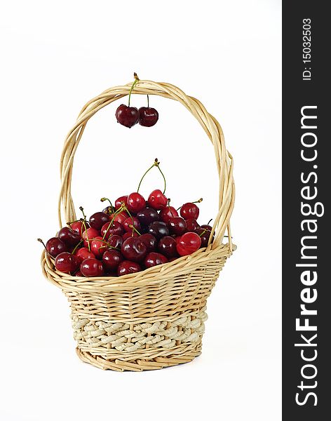 Wicker basket with fresh red cherries on the white background. Wicker basket with fresh red cherries on the white background