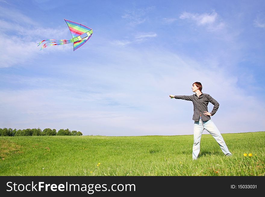 Young man in black shirt flying multicolored kite