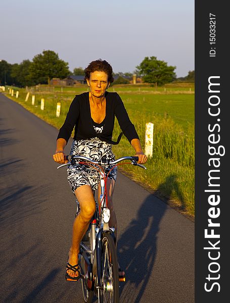 A women on a bicycle with evening light