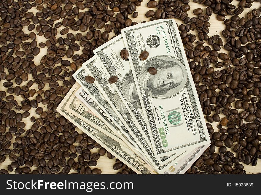 Amid scattered coffee beans packing dollars. Amid scattered coffee beans packing dollars