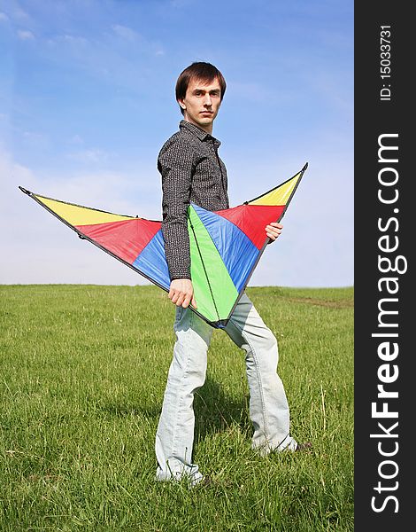 Young man in black shirt holding multicolored kite