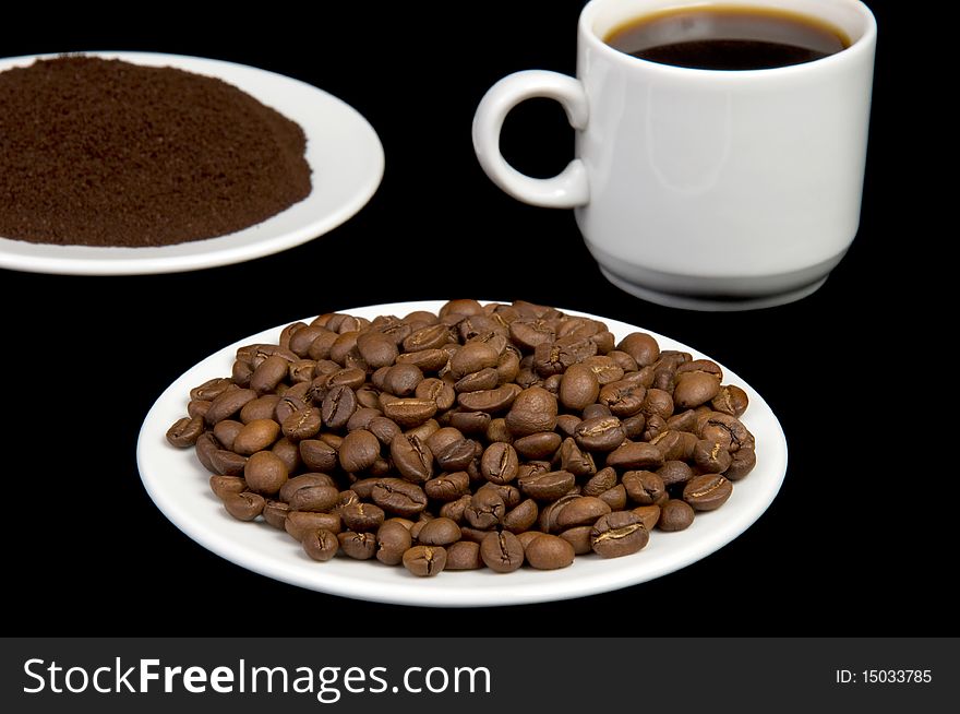 Plate with roasted coffee beans over black. Plate with roasted coffee beans over black