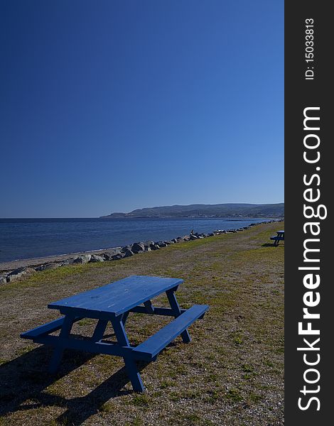 Shore of the Saint Laurent River in Quebec in the late afternoon with picnic table