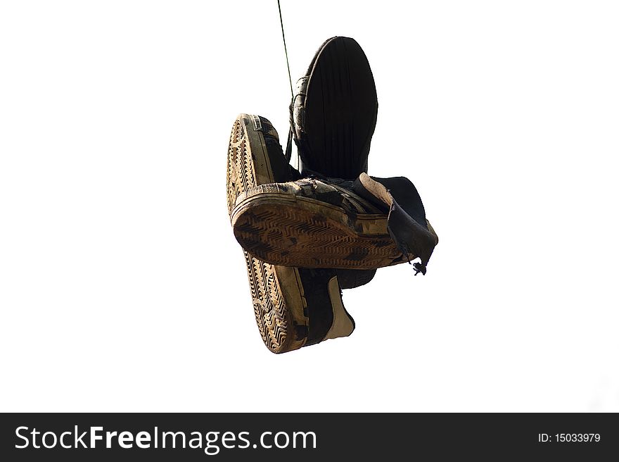 Old, torn up sporting trainers entangled by a lace on a light background. Old, torn up sporting trainers entangled by a lace on a light background