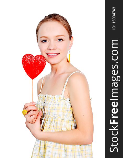 Pretty young girl with a heart shaped lollipop isolated on white background. Pretty young girl with a heart shaped lollipop isolated on white background