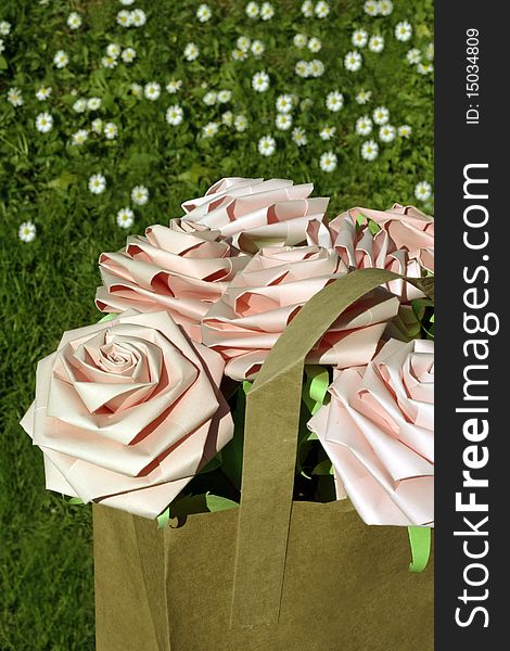 Pink paper roses in a brown paper bag