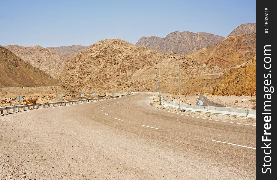 A main road winding through desert mountains. A main road winding through desert mountains