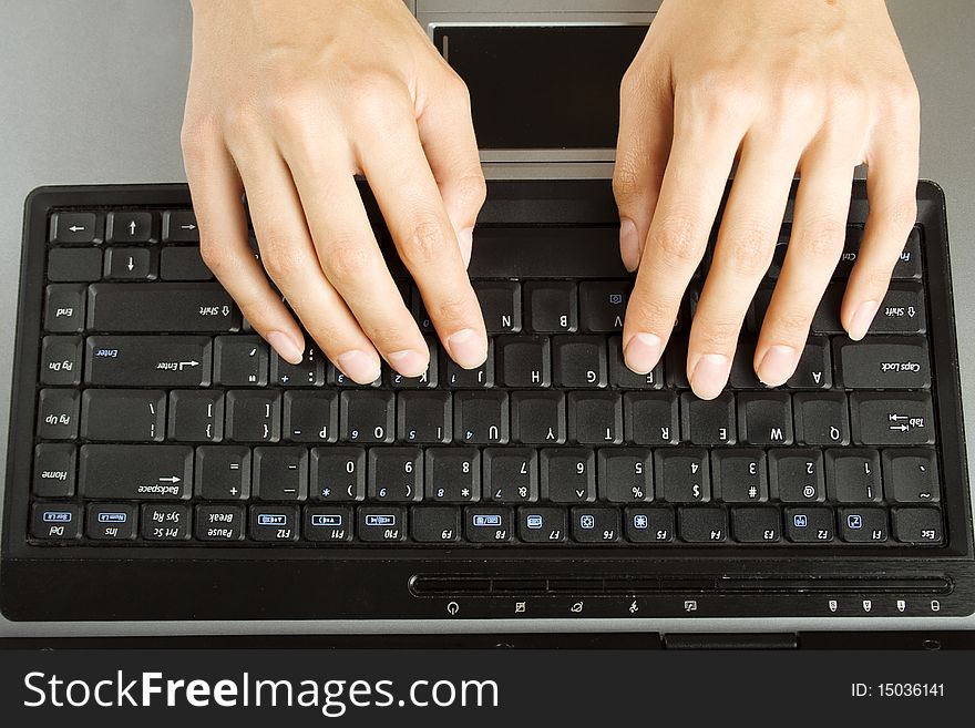 A woman's hands typing on a laptop. A woman's hands typing on a laptop