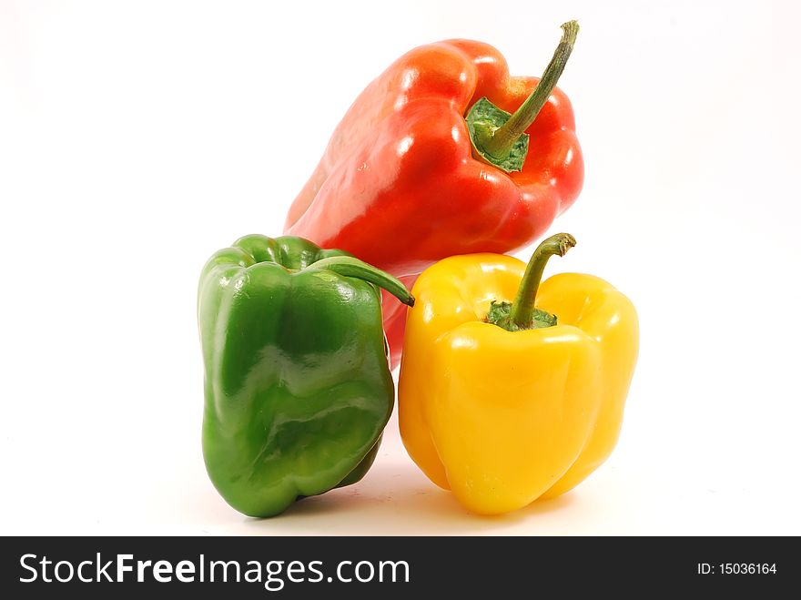 Yellow peppers, red and green on white background