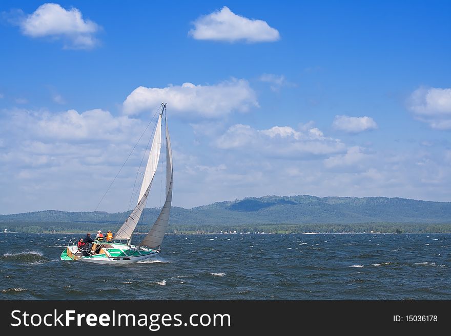 A yacht on the lake with the mountains in the background