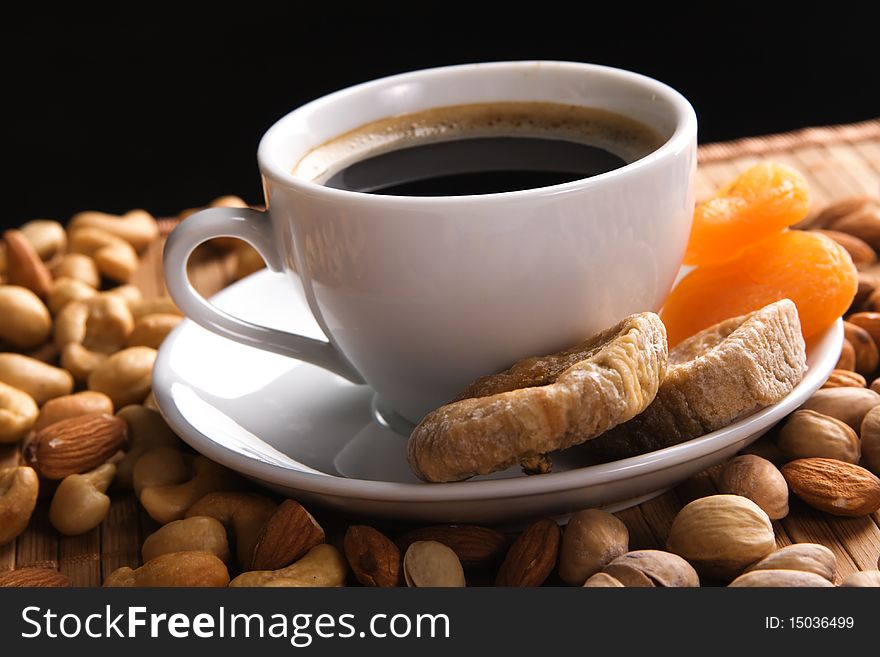 Coffee with nuts, fig and dried apricots still life