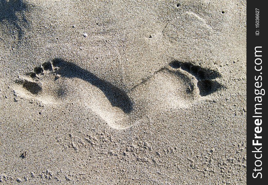 Human footprints on a beach, justaxposed like a butterfly