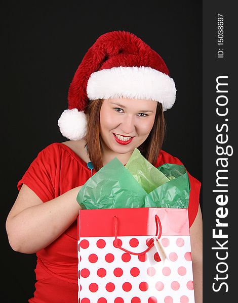 Cheerful young brunette wearing a red top and christmas hat. Cheerful young brunette wearing a red top and christmas hat