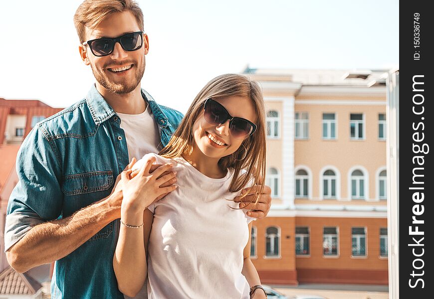 Portrait of smiling beautiful girl and her handsome boyfriend. Woman in casual summer jeans clothes. Happy cheerful family. Female having fun on the street background