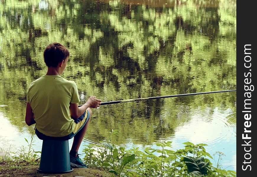 Teen child catches a fishing rod on the pond
