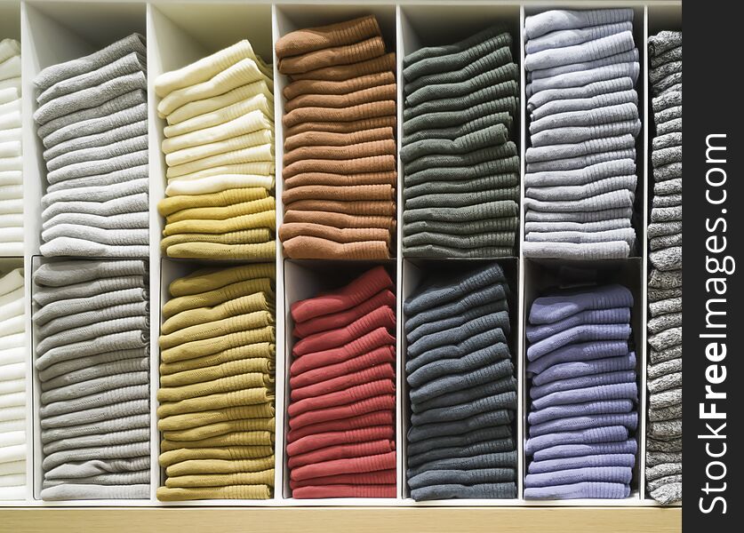Cotton T-shirt folded neatly in the showroom,Colorful clothes folded in the cabinet,Colorful clothes neatly dressed,Shelves and
