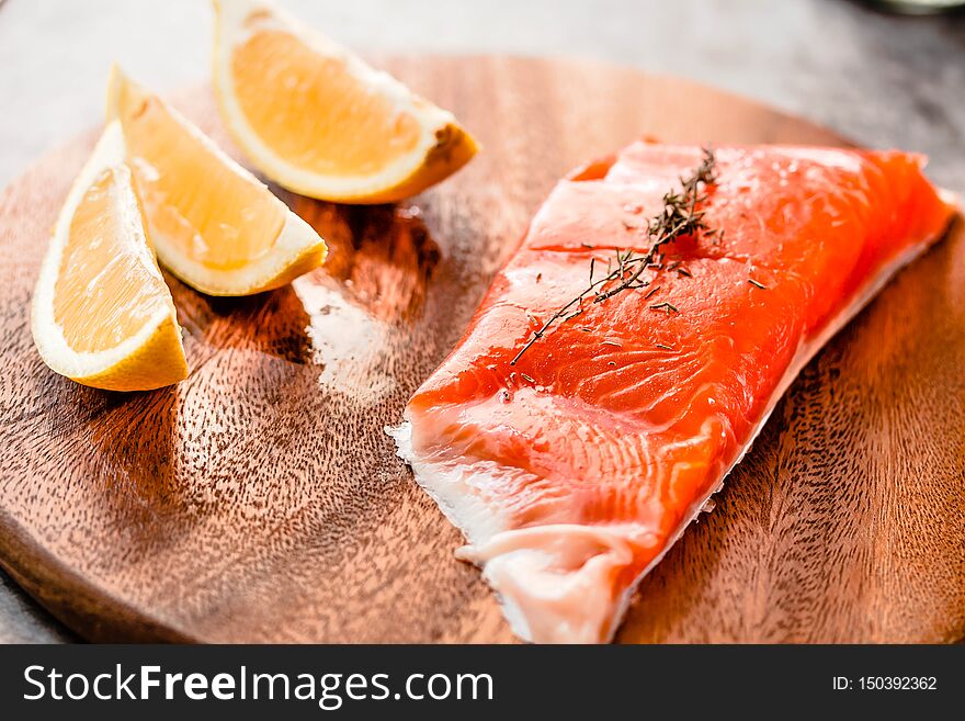 Raw salmon fish filet with lemon and spices. On a wooden background.