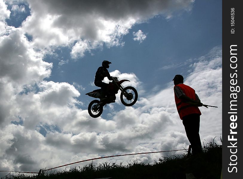 Motorcross rider jumping high at a jump