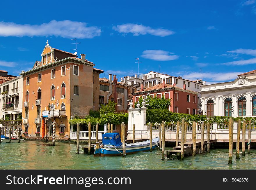 Boat in the waters of the Grand Canal surrounded by the historic palaces and medieval villas in Venice, Italy. Boat in the waters of the Grand Canal surrounded by the historic palaces and medieval villas in Venice, Italy.