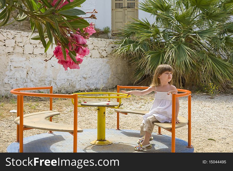 A little girl on carousel  in playground