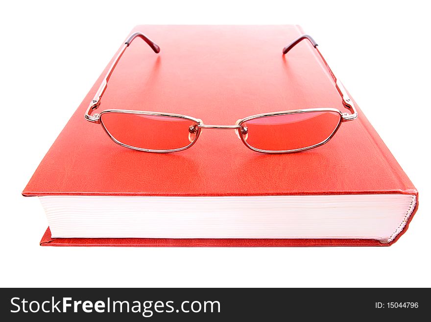 Closed book and glasses on a white background. Closed book and glasses on a white background